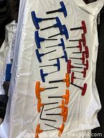 Photo showing multiple T-handle Allen keys in blue, red, and orange colors arranged on white surface, variety of sizes.