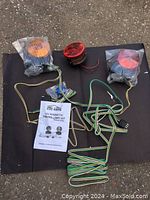Three round magnetic towing lights – two amber and one red – with attached wiring and connectors, laid on black mat. Assembly and operating instructions visible.