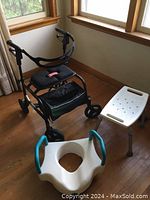 Wide angle showing all three items: black rollator walker with seat, white commode riser seat, and white shower stool.