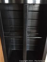 Photo of the shelving unit showing multiple horizontal shelves with dark wood finish and vertical supports.