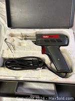 Photo of Weller soldering gun with attached power cord in foam-lined compartment.