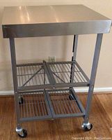 Front view showing solid flat top and wire mesh bottom shelves with caster wheels.