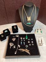 Full lot overview on black display, showing all jewelry pieces including rings, earrings, necklace, and brooches