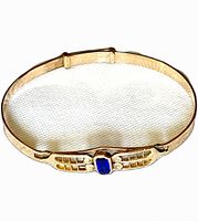 Front view of antique gold-filled bangle bracelet showing blue glass center and sliding expansion mechanism