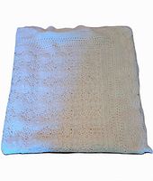 Folded view of the large crocheted cotton tablecloth or bedcover, showing part of the intricate stitched pattern.