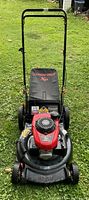Front view of the Honda GCV 160 engine mounted on a Troy-Bilt lawn mower with grass catcher bag and handlebar visible.