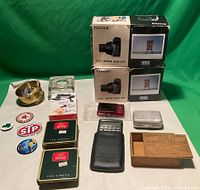 Full view of all lot items including cameras, tins, pins, calculator, ashtray, and boxes.