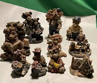 Front view of ten vintage resin figurines arranged with green background