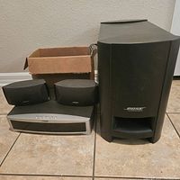 Front view showing all main components of the Bose Media Center AV3-2-1II system including subwoofer, media center unit, and two satellite speakers.