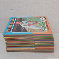 Stack of vintage baseball cards with Ron Schueler Phillies card on top showing colorful border and player image.
