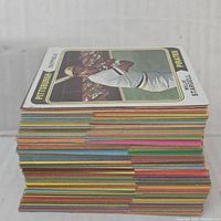 Side view of a large stack of vintage baseball cards showing colorful edges and thickness of the collection