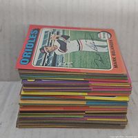 Stack of various colorful vintage baseball cards with Mark Belanger Orioles card on top.