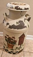 Front and side view of vintage distressed metal milk can showing painted birdhouse and flowers with chipped cream paint and rust areas.
