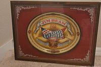 Overall view of vintage Jim Beam advertising tray in shadowbox frame on carpeted floor.