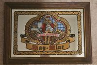 Front view of the framed vintage Melkmeister May-Mine Wine mirror showing central colored illustration and text within a decorative border.