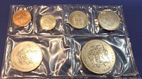 Front view of six uncirculated 1969 Jamaican proof coins sealed in plastic with various sizes and denominations.