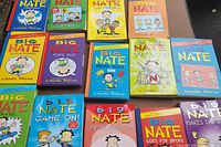 Photo of 15 Big Nate books by Lincoln Peirce arranged on a table showing colorful covers and titles.