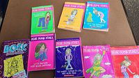 Eight children's chapter books arranged on table with visible covers, showing mostly Dear Dumb Diary titles and one Dork Diaries book.