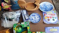 Photo showing all items including hats, wooden bowls, plates, golf games, paint set, and small figurine