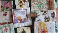 Photo showing variety of sealed paper napkins with floral and holiday designs arranged on a surface.