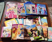 Overview of assorted Disney children's books including a playable piano book, multiple storybooks featuring Winnie the Pooh, Disney princesses, Mickey and friends, and other titles.