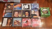 Photo showing 11 assorted classical music CDs laid out, including composer portraits and thematic classical music covers.