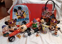 Photo showing the assorted Disney items on display including toddler backpack, various character figurines, Mickey Mouse themed red lightsaber, and Star Wars lap tray bag.