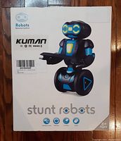 Front of Kuman Stunt Robots box showing the blue and black robot toy on wheels and key features.