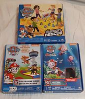 Three Paw Patrol game boxes: Mission Rescue, Adventure Game, Save the Octopus