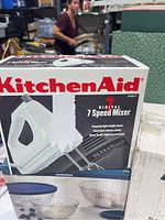 KitchenAid 7 speed digital hand mixer in original box shown from front and side angles.