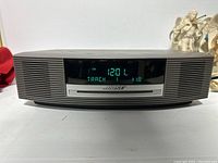 Front view of Bose Wave Music System showing digital display with time 12:01 and track 18 playing on CD.