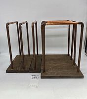 Photo showing two handmade craft display stands side by side, made from copper piping and wood bases.