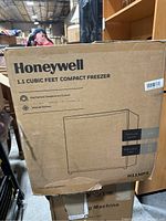 Box of Honeywell 1.1 Cubic Feet Compact Freezer with product details and specs visible.