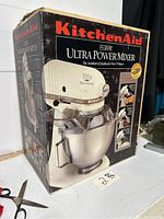 Front left angle view of original box showing mixer image and branding