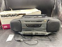Front view of vintage Magnavox AZ 8310 CD radio cassette recorder boombox with original box and power cord shown.