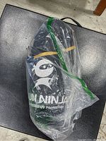 Photo of black carrying case with Sun Ninja branding and text 'Undercover UV Protection' visible through clear plastic bag.