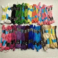 Overhead photo of embroidery yarn skeins in multiple colors including whites, greens, yellows, oranges, pinks, purples, blues, and browns.