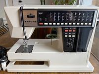 Front and side view of sewing machine showing open arm area and needle plate.