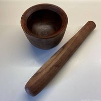 Wide view showing the large mortar bowl and the full length of the pestle.