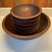 Top down view showing the large bowl with six smaller bowls stacked inside, highlighting the wood grain and finish.