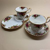 Photo of two Royal Albert Old Country Roses fine china cups and saucers, one cup with regular round saucer, one cup with oval saucer plate