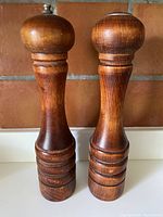 Front view of vintage Baribocraft pepper grinder and salt shaker made of turned maple wood with warm brown finish.