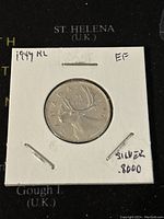 Reverse side of the 1947 Canadian 25 cent silver coin showing a caribou and inscription 'CANADA 25 CENTS'. Mounted in protective flip.