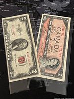 Both 1953 US $2 Silver Certificate and 1954 Canadian $2 banknote shown together inside protective sleeves.