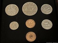 View of 7 Canadian coins laid out in specimen condition showing obverse and reverse sides with detailed designs including coat of arms, animals, and queen profile.