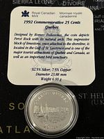 Coin with informational insert card describing design, composition, and features of the 1992 Canadian silver proof 25 cents Quebec commemorative coin.