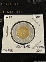 Photo of reverse side of the proof Canadian Twoonie showing polar bear design, silver outer ring and gold-plated center.