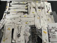 Overview of assorted jewelry items including bracelets, necklaces, and earrings in original packaging spread out on a surface.