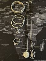 Photo showing the full collection of sterling silver jewelry items laid out on a map background for size and detail reference.