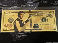 Front of Han Solo themed $100 gold foil novelty bill showing character and designation details on black map background